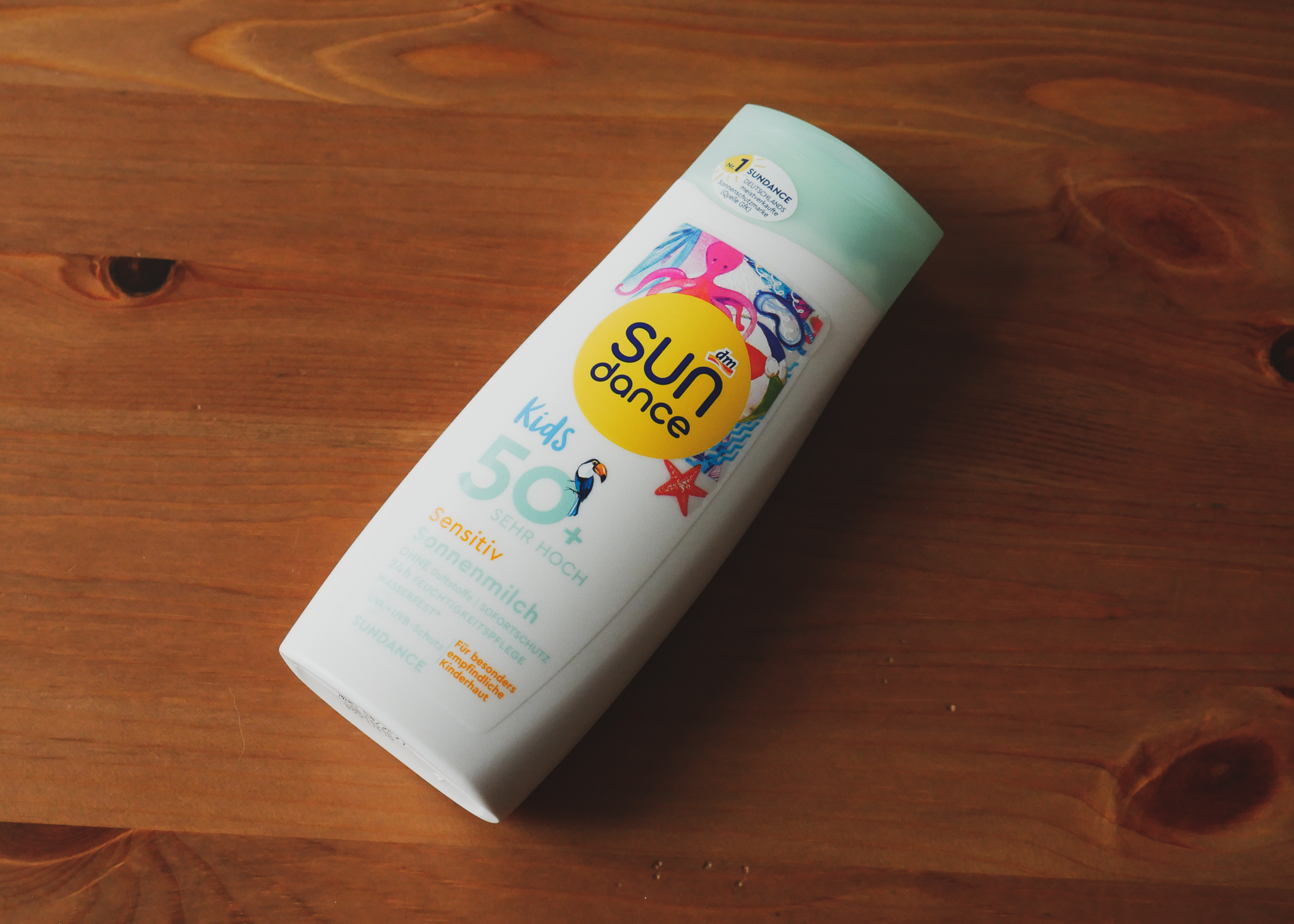 Sun Dance Kids Sensitiv Sonnenmilch SPF 50+ auf Holzgrund